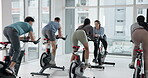 People, coach and fitness with bike at gym for exercise, cardio training and indoor cycling. Smile, group and instructor with bicycle machine, endurance workout and intense performance at spin class