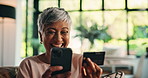 Mature woman, phone and credit card on sofa, happy or discount for ecommerce, sale or deal in home. Person, smartphone and mobile app for fintech, excited or easy payment for online shopping at house
