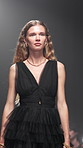 Event, fashion show and style with woman model on runway for launch or premiere of clothing line. Attitude, creative and design with person in clothes outfit for studio presentation or showcase