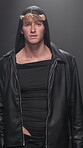Fashion show, runway and style with model man at event for launch or premiere of clothing line. Catwalk, creative and stage with person in designer clothes outfit for studio presentation or showcase