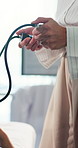 Hands, doctor and patient with blood pressure, exam and assessment for hypertension at hospital. People, medical equipment and consulting for wellness, test and monitor with services at clinic