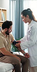 Doctor, man and exam with blood pressure at clinic, assessment and check for hypertension. Woman, medical equipment and consulting with patient, test and monitor with healthcare services at hospital
