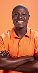 Happy, face and man with arms crossed, fashion and pride with stylish clothes and orange background. Confident, trendsetter and black person with unique outfit, studio and model with tshirt in Kenya