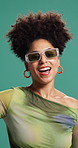 Face, dancing and woman in studio, celebration and movement  on green background. Portrait, happy person and model with energy, confidence and sunglasses with fashion, stylish clothes and cheering