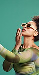 Selfie, peace sign and woman in studio, fashion and confident personality on green background. Person, hand gesture and happy model with sunglasses, blow kiss and gen z with stylish clothes and emoji