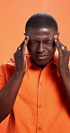 Black man, headache or brain fog in studio for anxiety, stress or depression on a orange background. Male person, African model or migraine with vertigo, strain or pressure for fatigue or dizziness