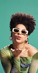Woman, blow kiss and sunglasses in studio, happy or confident with trendy style by background. African person, girl and pout with smile, heart hands or symbol for love, kindness or flirt with fashion