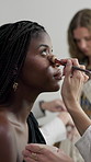 Hands, makeup and artist with model backstage for beauty, preparation and cosmetic glamour. People, beautician and brush application with powder, makeover process and behind the scene for photoshoot