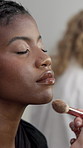 Hands, makeup brush and woman in dressing room with powder, application and face for fashion show. People, runway model and artist with tools, equipment and foundation with cosmetics for beauty