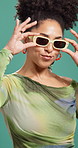 Fashion, sunglasses and face of woman by studio background with trendy and funky clothes. Happy, creative and portrait of female person with cool outfit and accessories for style with confidence.