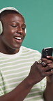 Black man, headphones and dancing in studio with phone, streaming and sound by background. African person, smartphone and singing with audio subscription, happy and listen to music with mobile app