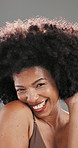 Face, laugh and hair with black woman in studio for curly pattern, natural afro texture and growth. Shampoo cosmetics, volume and glow with person on gray background for salon treatment and shine