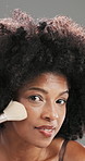 Beauty, face and woman with makeup brush in studio for makeover or cosmetics application. Facial, product and smile of happy African model with tool for aesthetic, blending foundation or contour