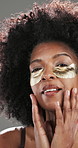 Beauty, eye patches and face of black woman in studio with natural, hydration or collagen routine. Skincare, portrait and African female person with facial dermatology treatment by gray background.