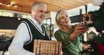 Elderly, happy couple and christmas with tree decor for celebration or christian holiday in home. Senior, man and woman hanging with hug, bauble or ornaments for december or festive decorations