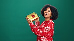 Christmas, present and face of black woman in studio with celebration, happiness or giveaway prize. Mockup space, portrait and African female person with gift box for xmas holiday by green background