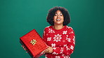Christmas gift, laugh and face of black woman in studio with celebration, happiness or giveaway prize. Curious, portrait and African female person with gift box for xmas holiday by green background.