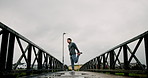 Stretching legs, fitness and man on bridge in city for running, marathon training and workout. Sports, challenge and person warm up with exercise outdoor for muscle strength, mobility and wellness