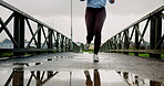 Running, shoes and fitness with woman in city for athlete, marathon practice and health. Wellness, exercise and sports workout with legs of person training outdoor on bridge for resilience and cardio