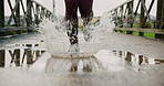Running, shoes and puddle with person in city for splash, marathon practice and health. Wellness, exercise and sports workout with legs of runner training outdoor on bridge for resilience and cardio