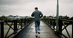 Back, running and man in city, exercise and cardio with training with wellness, energy and health. Outdoor, person and runner with muscle development, practice and progress with challenge and fitness