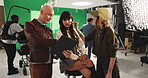Makeup, styling and tablet with director on set for advertising, production or videography. Behind the scenes, conversation and green screen with man speaking to talent in studio for film direction