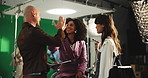 High five, makeup and tablet with director on set for advertising or production success. Behind the scenes, green screen and styling with man speaking to talent in studio for videography satisfaction