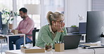 A mature blonde business woman wearing spectacles looking bored and tired at work while sitting in front of her computer