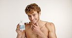 Face, happy man and perfume in studio for skincare, grooming and fragrance on white background. Cologne, fresh scent and model with cosmetics product for self care, confident and laugh with space