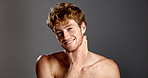 Face, skincare and man in studio for shine, glow and beauty on gray background. Portrait, smile and touch with model for hydration, collagen treatment and wellness with cosmetics for dermatology