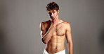 Face, skincare and man in studio, topless and cosmetics with dermatology on gray bakground. Portrait, person and model with shine, beauty and muscular with grooming, body care and hygiene with glow