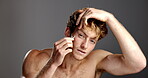 Face, facial treatment and man with tweezers for eyebrow, gray background and trimming for grooming. Hair removal, routine and person with tool for process, studio and confident with equipment