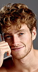 Face, skincare and smile of man in studio for grooming, hygiene or masculine beauty or wellness. Aesthetic, satisfaction and self care with happy model on gray background for facial dermatology