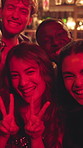 Face, peace sign and people in club, smile and neon lights with celebration, funny and excited. Portrait, happy group and friends with event, party and energy with freedom, profile picture or gesture