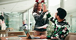 Christmas, team and people in office, high five and celebration for research on website and success. Happy, colleagues and gesture for achievement in business, festive season and smile for laptop