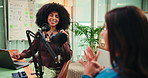 Content creation, women and host with mic for podcast, creative and live streaming interview on web. Happy, people and laughing with guest in studio, conversation and podcaster with laptop for audio