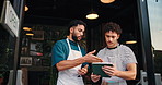 Waiter, men and discussion with tablet at coffee shop, listen and review for stock, results or menu at front door. People, talk and barista with solution, tech and app with sales report at diner