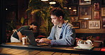 Coffee shop, hybrid work and man typing on laptop to research story or review email for journalism. Computer, drink and freelancer in cafe for news article, editing headline or fact checking at night