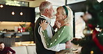 Senior, happy couple and dancing with hug in home for christmas celebration or december holiday. Elderly, man and woman with smile or embrace in joy for romance, festive or bonding together in house