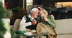 Christmas, coffee and toast with old couple on sofa in living room of home for festive celebration. Cheers, hug and love with happy senior people in apartment for bonding, holiday or vacation