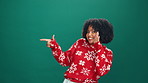 Woman, pointing and promotion for Christmas, face or advertising in festive season and announcement. Studio, mockup space and African person with smile for holiday offer, green background and sale