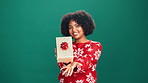 Christmas, present box and face of black woman in studio with celebration, happiness or giveaway prize. Excited, portrait and African female person with gift box for xmas holiday by green background.