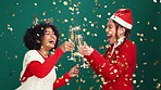 Christmas confetti, friends and toast with champagne to celebrate holiday, laugh or excited. Xmas, happy women and cheers with alcohol for festive party, dance or sparklers on green studio background