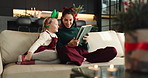 Christmas, mother and child with tablet in home for festive movie, learning and laughing together. Xmas, girl and happy parent with tech on sofa for holiday film, decoration ideas and gift shopping