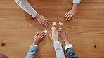 Top view, hands and business people with puzzle for team building, cooperation and problem solving. Above, group and jigsaw piece for collaboration, connection and synergy on table for strategy