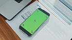 Phone, green screen and documents in empty office for accounting, finance report and performance. Mockup space, mobile app and paperwork of financial planning, tax information and investment proposal