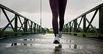 Running, shoes and health with person in city for travel, marathon practice and fitness. Wellness, exercise and sports workout with legs of runner training outdoor on bridge for resilience and cardio