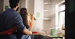 Couple, choice and hug with painting for kitchen renovations, upgrade and maintenance. New home, man and woman back for diy, makeover and decoration decision with creative homeowner and art tools