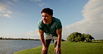 Tired runner, man and rest at park by river with fitness, sweat and breathe with training stats. Person, athlete and check smart watch for timer, low angle and speed on break for workout in Mexico