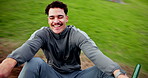 Face, laughing and roundabout with man at playground for excitement, freedom or fun outdoor. Activity, funny and spinning with happy person on merry go round in park for holiday, vacation or weekend